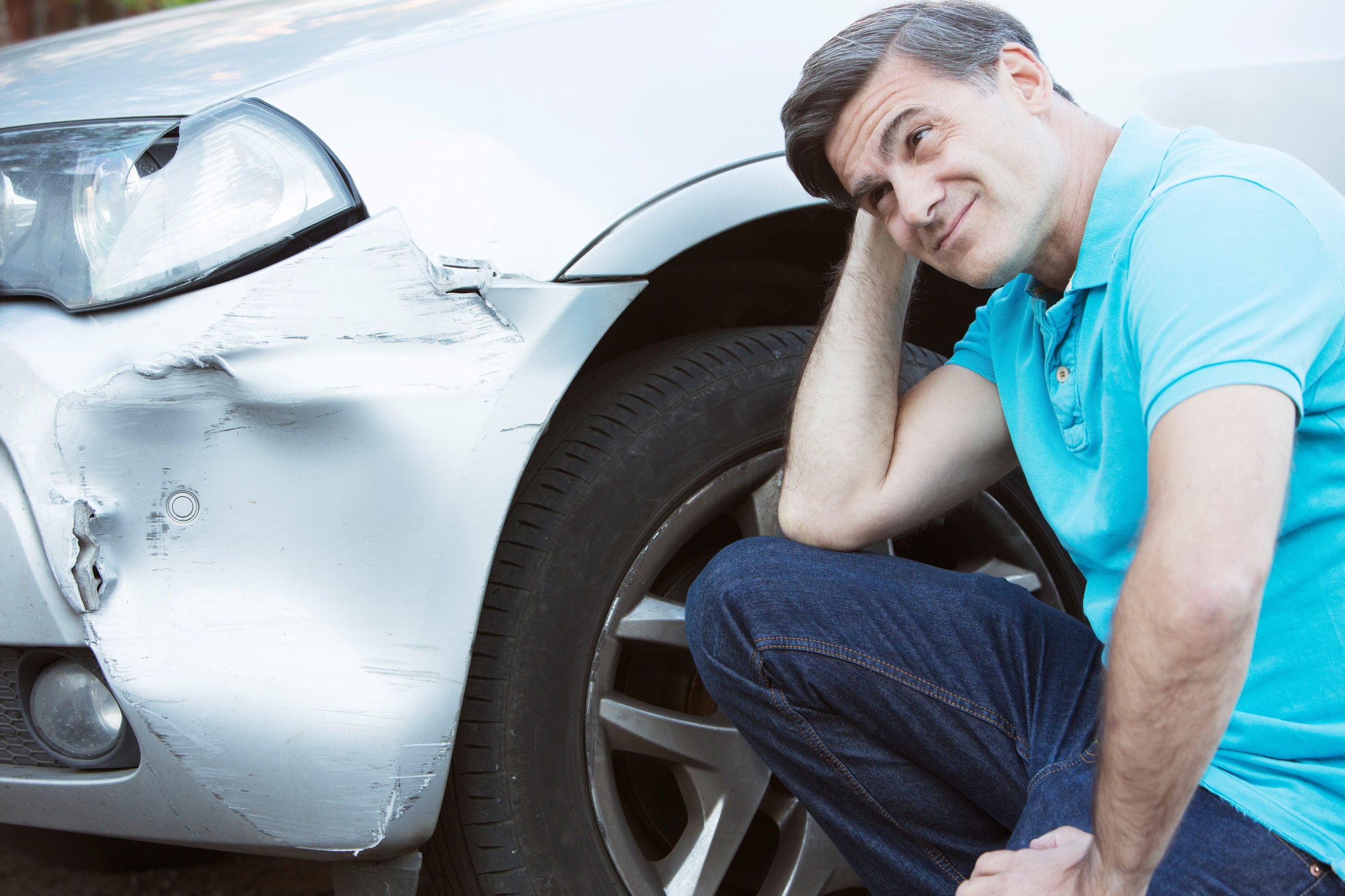 Unhappy Driver Inspecting Damage After Car Accident